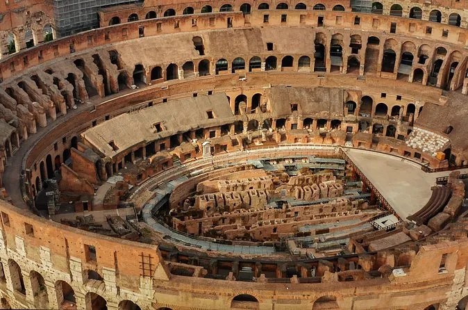Tout l'intérieur du Colisée vu d'un gradin supérieur, avec la plateforme de l'arène au fond et l'hypogée qui occupe le centre